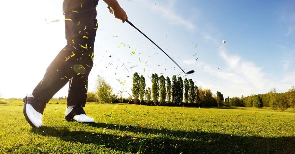 Golfer performs a golf shot from the fairway.